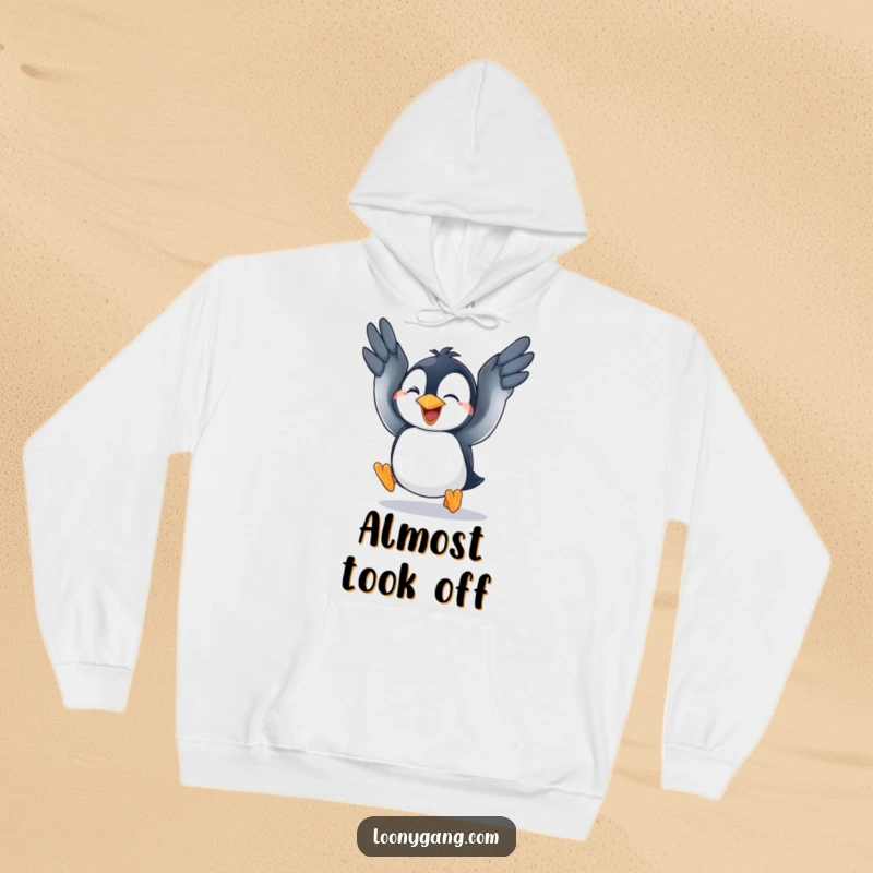 A comfortable hoodie showcasing a funny penguin cub enthusiastically flapping its wings in a comical attempt to achieve flight.