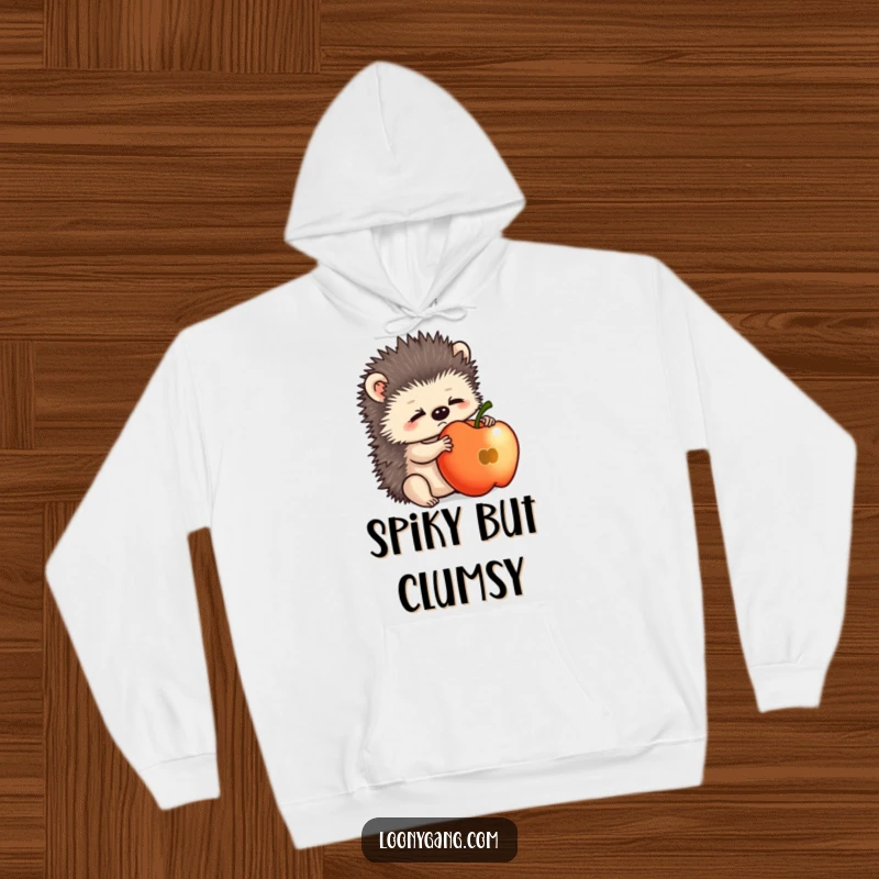Funny hedgehog cub looking perplexed while balancing an apple, featured on a warm and comfortable hoodie.