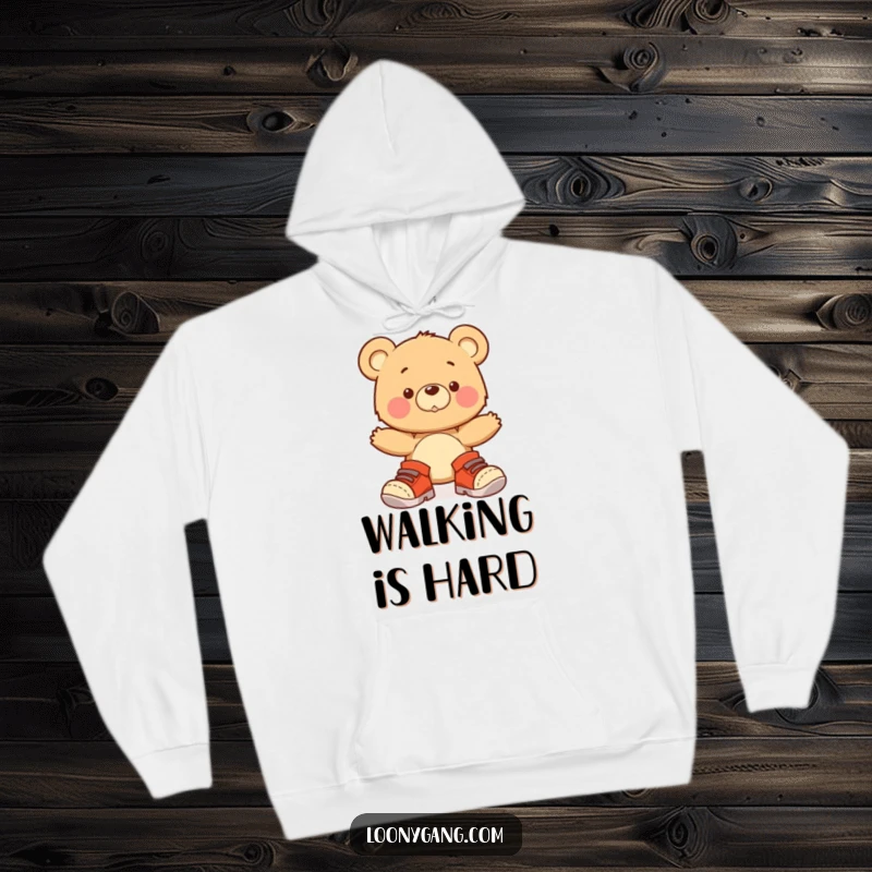 A comfortable hoodie featuring a funny bear cub attempting to walk in oversized shoes, wobbling with an endearing expression.