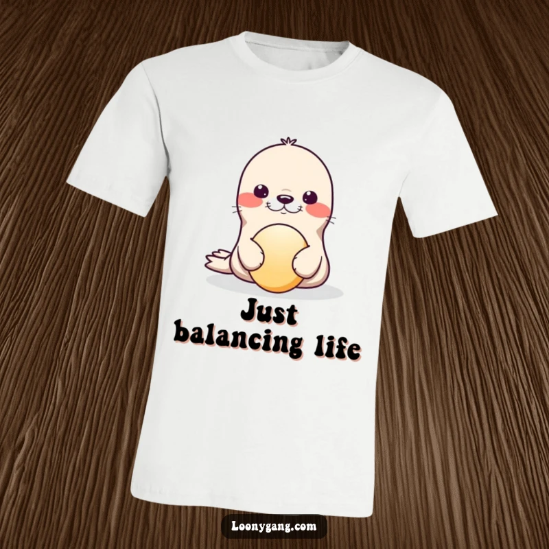 Funny T-Shirt showcasing a delightful seal comically balancing a ball on its nose, captured mid-wobble with pure joy.